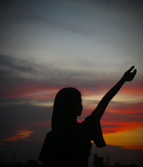 A person in a serene yoga pose against a dark blue and orange background.